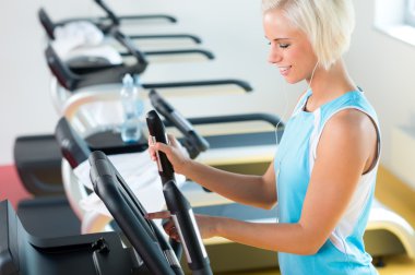 Fitness young woman on elliptical cross trainer clipart