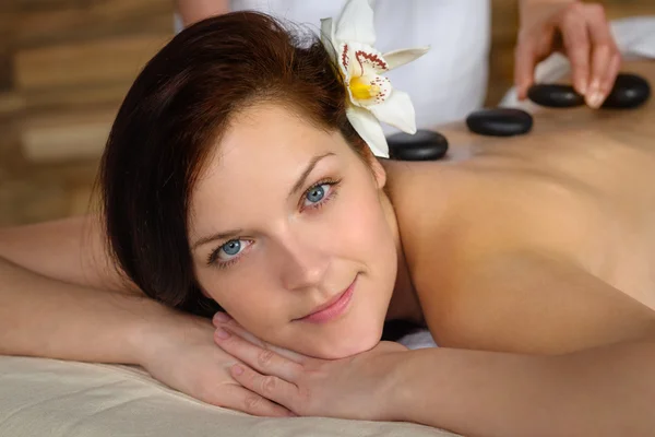 Жінка насолоджується гарячим лавовим кам'яним масажем спа — стокове фото