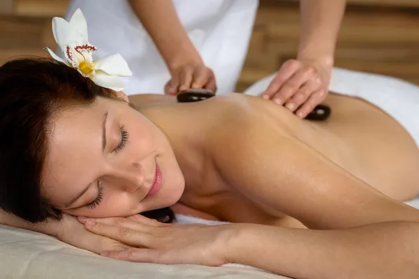 Quente pedra massagem mulher desfrutar de tratamento de spa — Fotografia de Stock