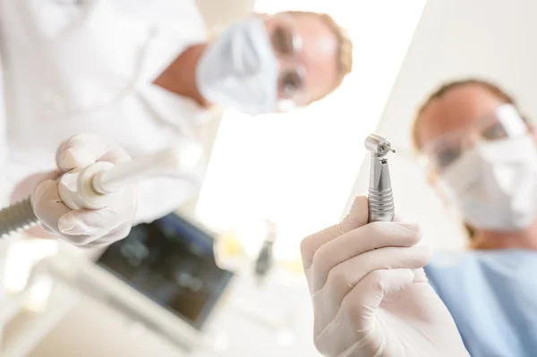 Dentista feminina e assistente foco na broca — Fotografia de Stock