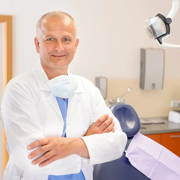 Зрелый стоматолог-хирург в офисе — стоковое фото
