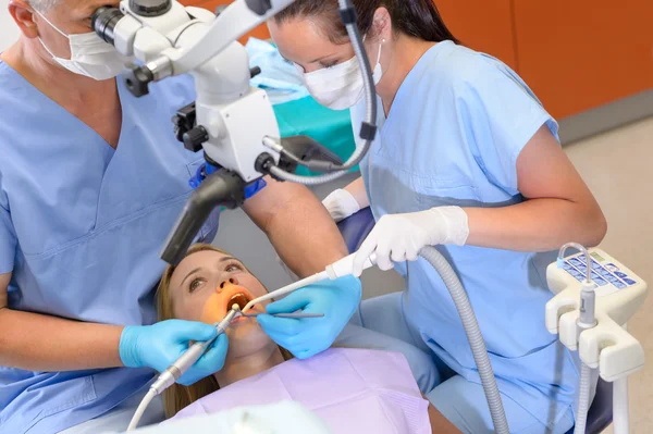 Zubař operace pacient přes mikroskop — Stock fotografie