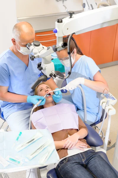 Οδοντίατρος λειτουργίας ασθενή μέσω μικροσκοπίου — Φωτογραφία Αρχείου
