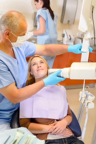Dentist taking x-ray of female patient