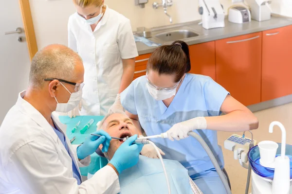 Стоматолог з медсестрами робить операцію на пацієнта — стокове фото