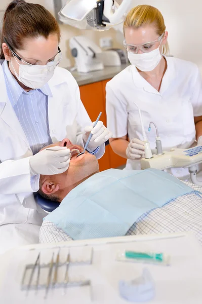 Dentista com enfermeira fazendo cirurgia no paciente — Fotografia de Stock