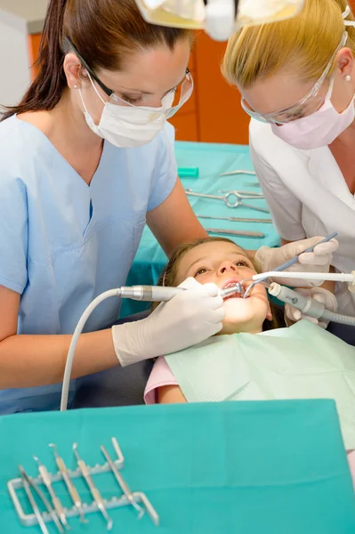 Dentista e enfermeira curando menina — Fotografia de Stock