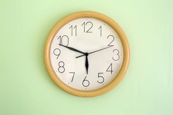 Saat duvarda asılı ve saati gösteren — Stok fotoğraf