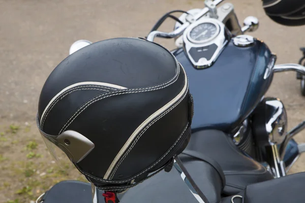 Black round bike helmet on leathered seat — Stock Photo, Image