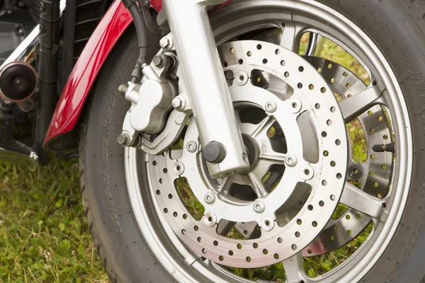 Bike chromed wheel on grassy background — Stock Photo, Image
