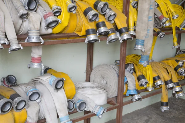 stock image Yellow firehose are hanging on warehouse shelfs