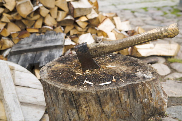 Rusty and used axe in wide stump