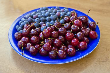 yaban mersini ve kiraz mavi plaka üzerinde yatıyordu