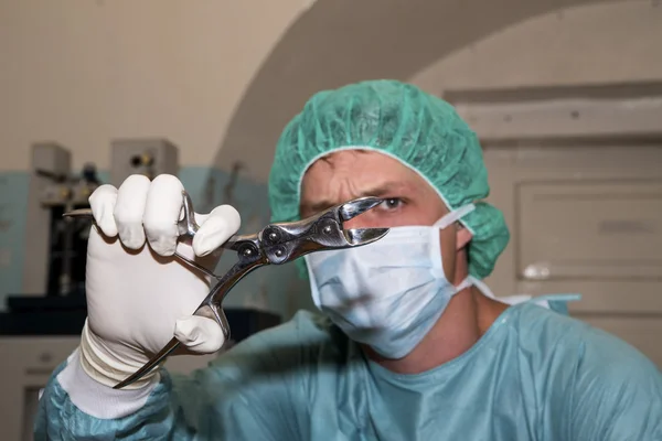 Chirurg Ukázat zvláštní nástroj před nadcházející chirurgie — Stock fotografie