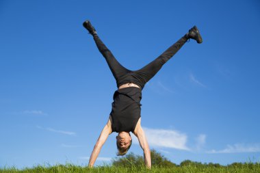 Sportsman is standing on hands for coordination clipart