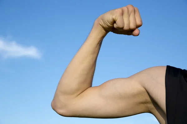 Esportista mostrar seus músculos quando esticar a mão — Fotografia de Stock