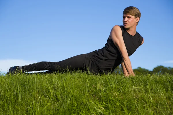 Sportsman är stretching dess mage och rygg — Stockfoto