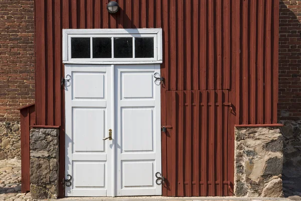 Wooden door in front of stony house — Stock Photo, Image