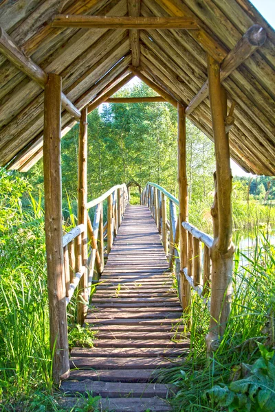 Wooden bridge ower calm lake at day — Stock Photo, Image