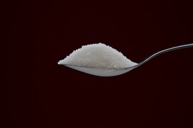 Pile of sugar on chromed spoon clipart