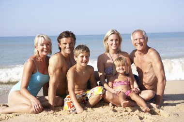 Three generation family pose on beach clipart