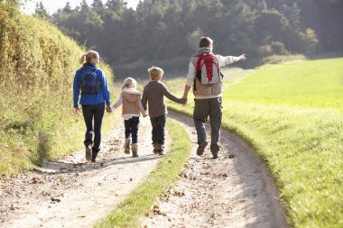 Young family walking in park clipart