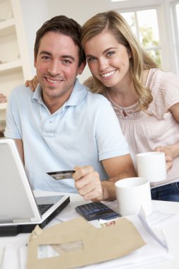 Young couple using credit card on the internet clipart