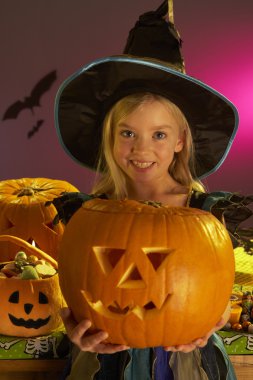 Halloween party with a child holding carved pumpkin clipart