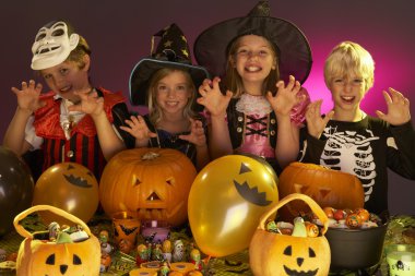 Halloween party with children wearing fancy costumes clipart