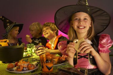 Halloween party with children having fun in fancy costumes clipart