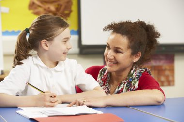 Schoolgirl Studying In Classroom With Teacher clipart