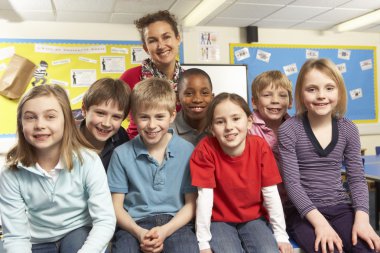 Schoolchildren In classroom with teacher clipart