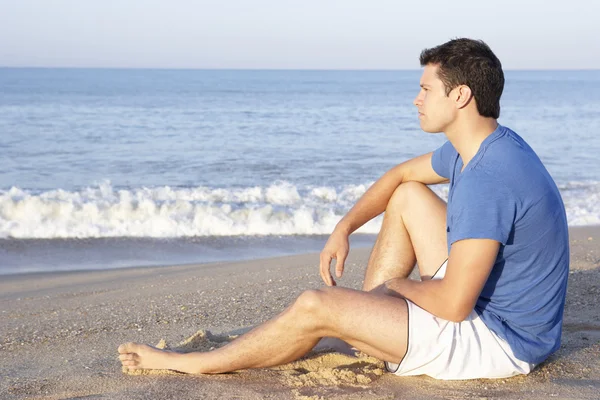 Άνδρας κάθεται στο χαλαρωτικό παραλία — Φωτογραφία Αρχείου