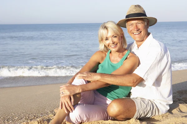 Senior koppel zittend op het strand ontspannen — Stockfoto