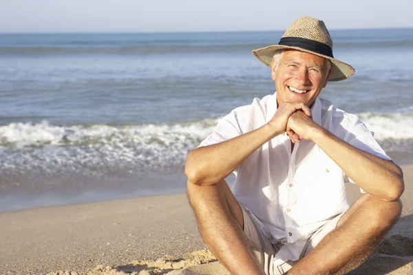 Ανώτερος άνθρωπος που κάθεται στο χαλαρωτικό παραλία — Φωτογραφία Αρχείου