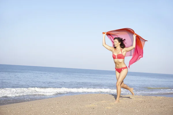 Junge Frau läuft am Strand — Stockfoto