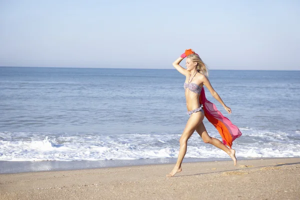 Junge Frau läuft am Strand — Stockfoto
