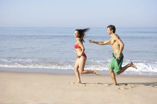 Молода пара біжить на пляжі — стокове фото