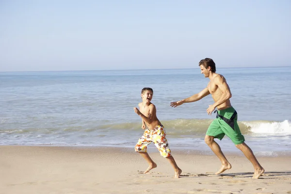Apja, kergeti a fiatal fiú a strandon — Stock Fotó