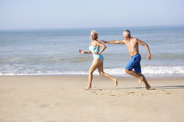 Senior couple running on beach — Stok fotoğraf