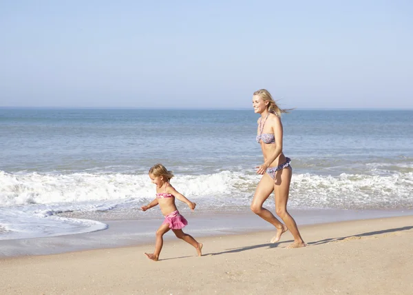Mutter jagt junges Mädchen am Strand — Stockfoto