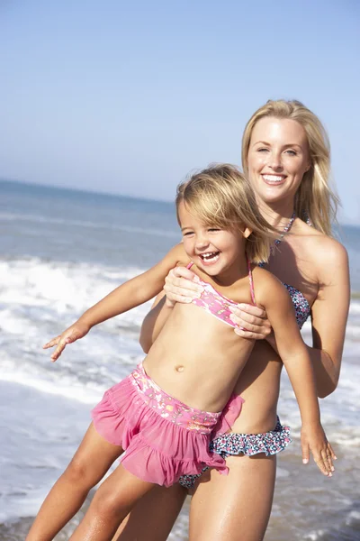 Mamma leker med ung flicka på stranden — Stockfoto