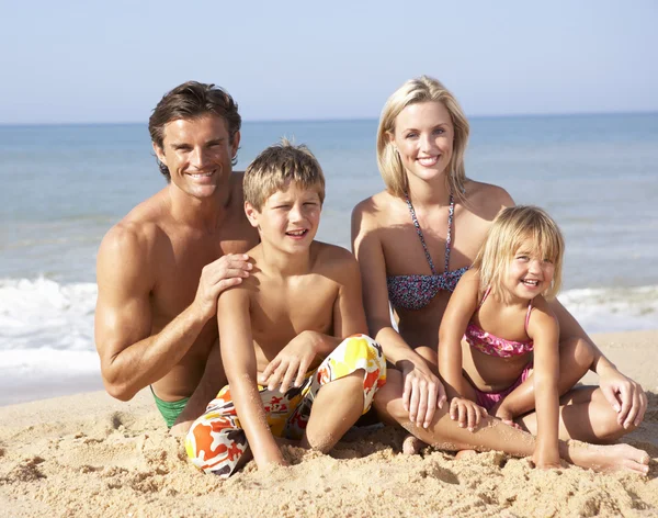 Ung familj pose på stranden — Stockfoto