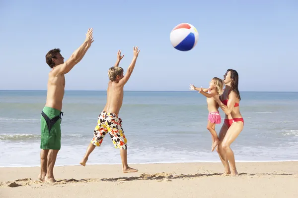 Молодая семья играет на пляже — стоковое фото
