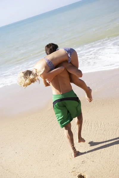 Young couple play on beach — Stock Photo, Image