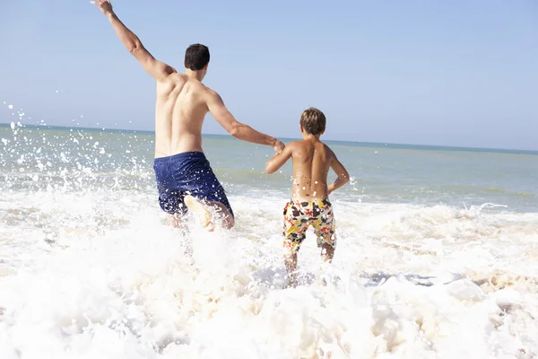 Padre jugando con un chico joven en la playa —  Fotos de Stock