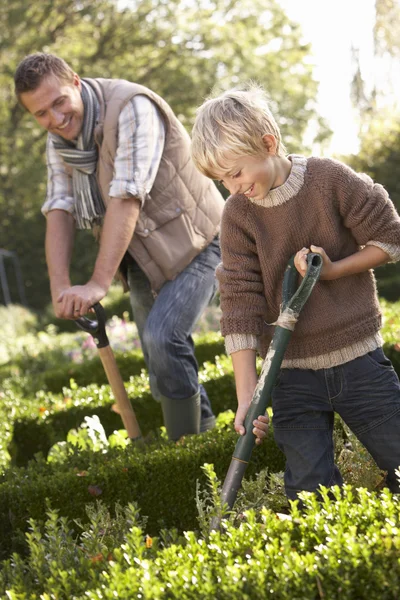 Young man with child working in garden — Stock Photo, Image