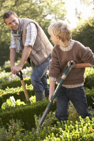 Jeune homme avec enfant travaillant dans le jardin — Photo