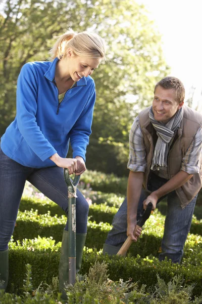 Young couple working in garden — Stock Photo, Image