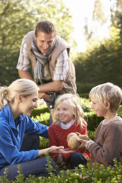 Jonge familie zitten samen in tuin — Stockfoto